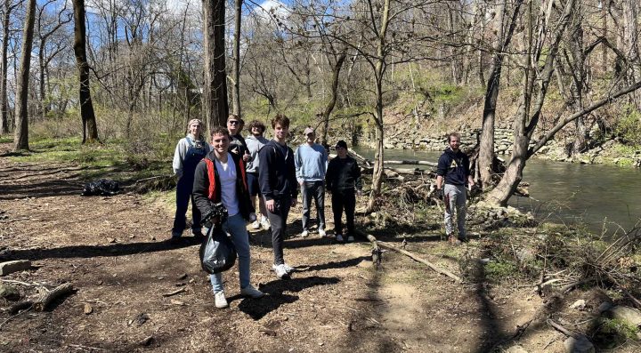 A group of Lafayette College students stand together by Bushkill Creek during a cleanup on the Karl Stirner Arts Trail in Easton, Pennsylvania.