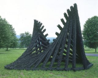 The black sculpture No More Milk and Cookies, made of recycled automobile tires and wood, was created by artist Chakaia Booker.