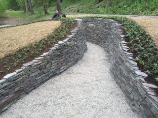 Lafayette College Professor Ben Cohen and another visitor explore the stone installation called Water Way created by artist Paul Deery on the Karl Stirner Arts Trail in Easton, Pennsylvania.