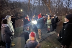People gather in a group at night during the Winter Solstice event on the Karl Stirner Arts Trail.