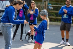 Organizer Lynn Schoof hands an award to a young girl at the Artful Dash 5K Run/Walk on the Karl Stirner Arts Trail in Easton, Pennsylvania.