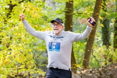 A man raises his arms and smiles at the Artful Dash 5K Run/Walk on the Karl Stirner Arts Trail in Easton, Pennsylvania.