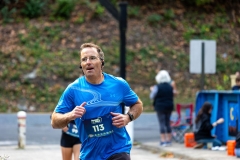 A man with a blue shirt runs by the blue McAteer Memorial Bridge at the Artful Dash 5K Run/Walk on the Karl Stirner Arts Trail in Easton, Pennsylvania.