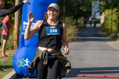 A woman waves after crossing the finish line at the Artful Dash 5K Run/Walk on the Karl Stirner Arts Trail in Easton, Pennsylvania.