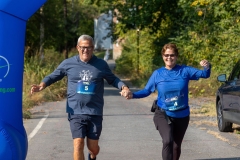 A man and woman hold hands by the finish line at the Artful Dash 5K Run/Walk on the Karl Stirner Arts Trail in Easton, Pennsylvania.