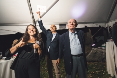 Melissa Starace gives the thumbs-up signal as two men stand near her  the Karl Stirner Arts Trail gala.