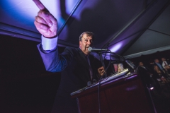 A man points while speaking at the podium during  the Karl Stirner Arts Trail gala.