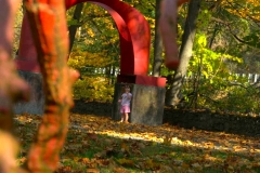 A child stands by the red arch sculpture on the Karl Stirner Arts Trail in Easton, Pennsylvania.