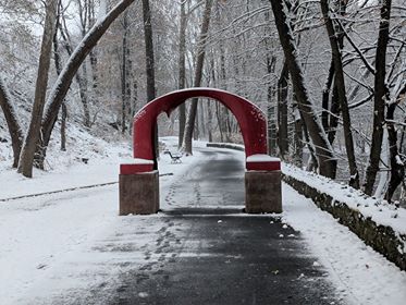 The iconic red arch sculpture stands on the snow-covered Karl Stirner Arts Trail.