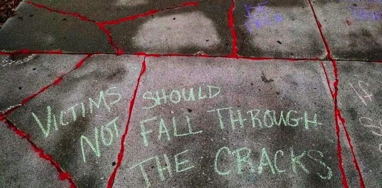 On the Karl Stirner Arts Trail in Easton, Pennsylvania, chalk words as part of the Red Sand Project say Victims Should Not Fall Through the Cracks.