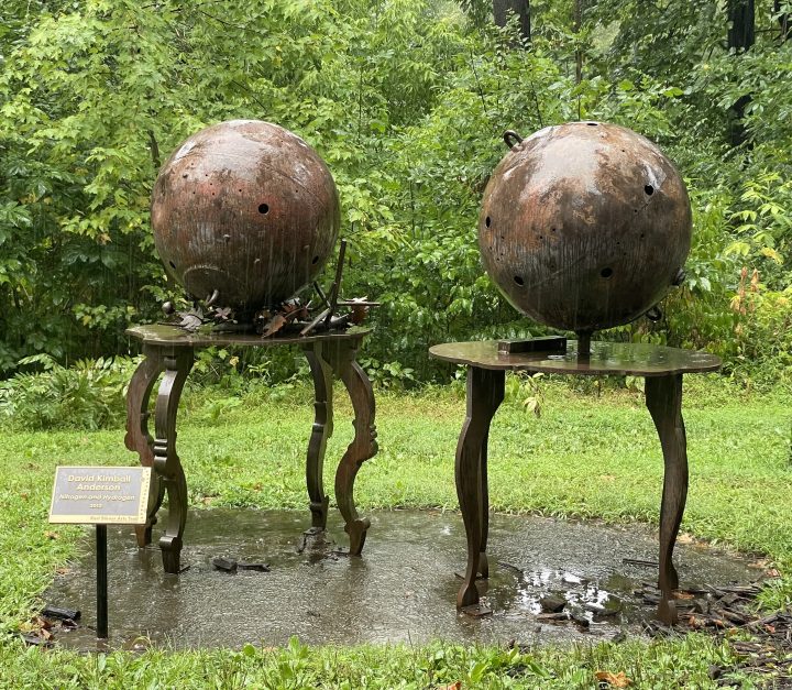 The two iron ball-shaped sculptures, Nitrogen and Hydrogen, by David Kimball Anderson, sit on metal pedastals on the Karl Stirner Arts Trail in Easton, Pennsylvania