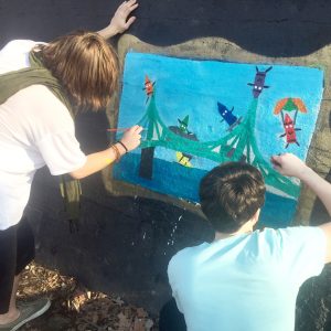 Two boys paint crayons as people on the Young Masters Wall at the Karl Stirner Arts Trail in Easton, Pennsylvania