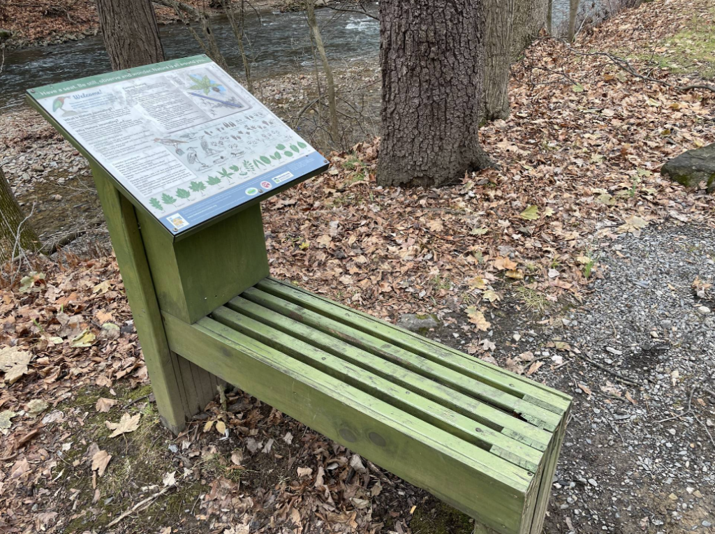 A journaling bench with a sign invites the public to sit, observe, and record the natural flora and fauna on the Karl Stirner Arts Trail in Easton, Pennsylvania.