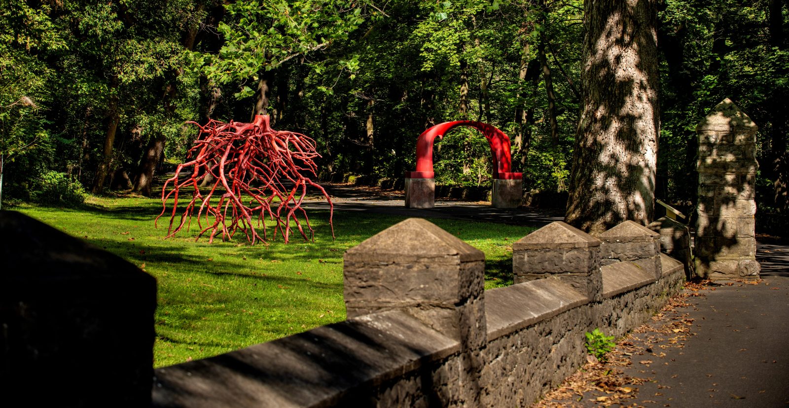 The Late Bronze Root red sculpture by Steve Tobin and the red Untitled arch sculpture by Karl Stirner on the Karl Stirner Arts Trail in Easton, Pennsylvania