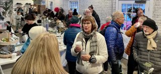 A crowd of people enjoy hot chocolate, cookies, and fellowship in Thrive at the Silk complex as part of a Winter Solstice celebration held by the Karl Stirner Arts Trail in Easton, Pennsylvania.