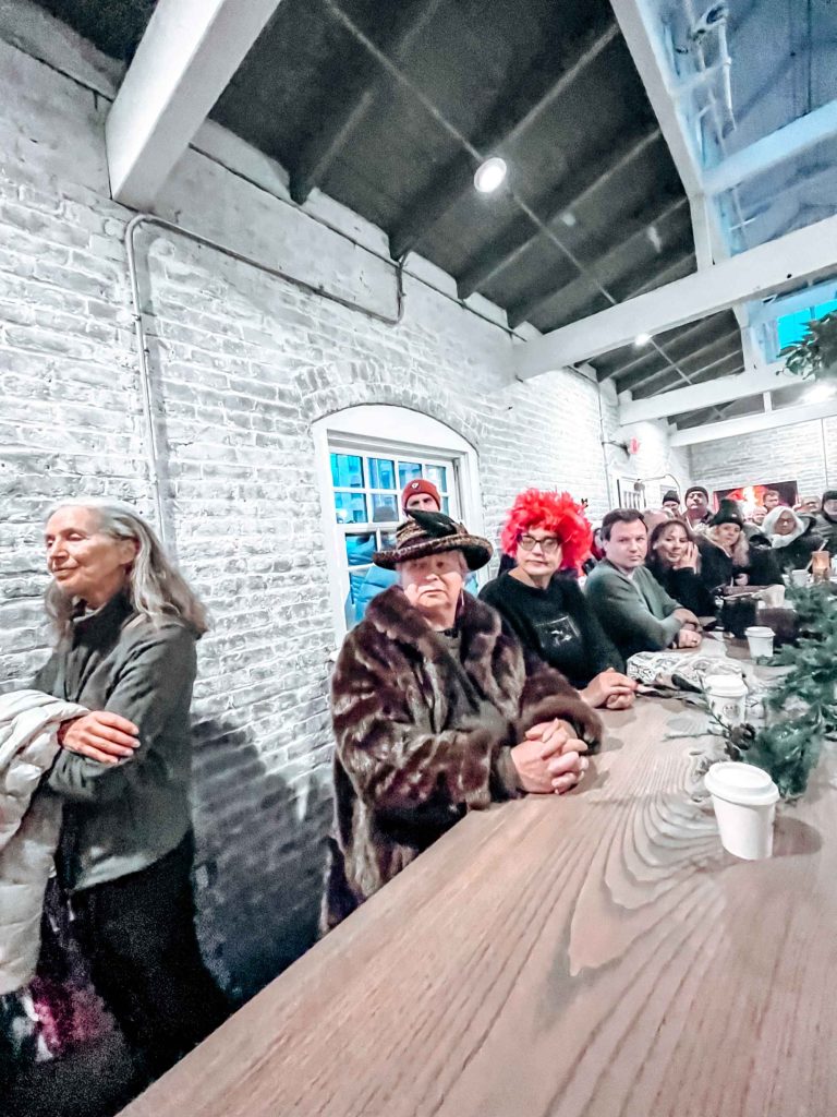 People sit at a long table during the Winter Solstice Walk hosted by Thrive Easton and the Karl Stirner Arts Trail in Easton, Pennsylvania.