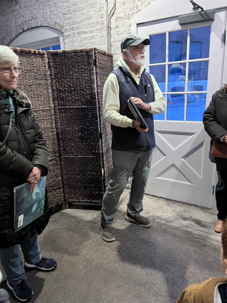 Peter and Randi Schmidt each hold a book while standing during storytelling time at the Winter Solstice Walk hosted by Thrive Easton and the Karl Stirner Arts Trail in Easton, Pennsylvania.