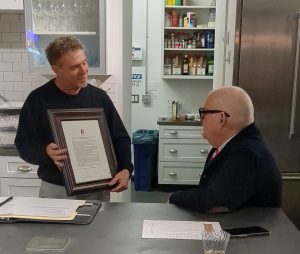 Karl Stirner Arts Trail Executive Director Jim Toia presents a resolution of appreciation to Ed Kerns in the Easton Public Market's test kitchen.