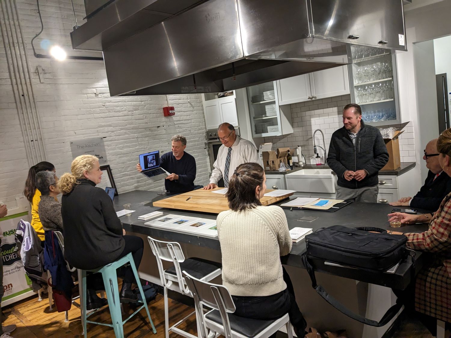 Members of the Karl Stirner Arts Trail Board of Directors, Easton Mayor Sal Panto, and Ed Kerns are gathered in the Easton Public Market's test kitchen in an event honoring Kerns.
