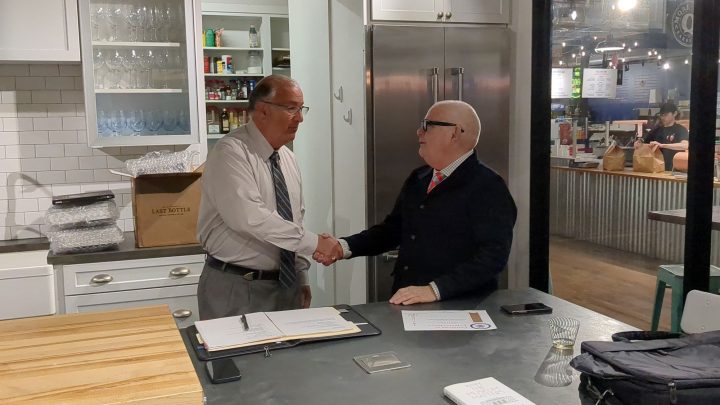 Easton Mayor Sal Panto shakes hands with Ed Kerns in the Easton Public Market's test kitchen as part of an event thanking Kerns for his leadership with the Karl Stirner Arts Trail in Easton, Pennsylvania.