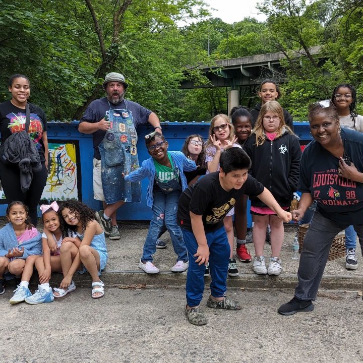 A group of children and program coordinator Danny Moyer pose for a group photo in front of the Young Masters Wall on the Karl Stirner Arts Trail in Easton, Pennsylvania.