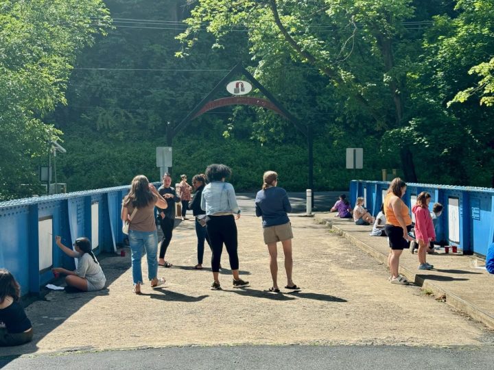Mothers accompany their children on the Richard McAteer Memorial Bridge as the kids paint on the Young Masters Wall at the Karl Stirner Arts Trail in Easton, Pennsylvania.