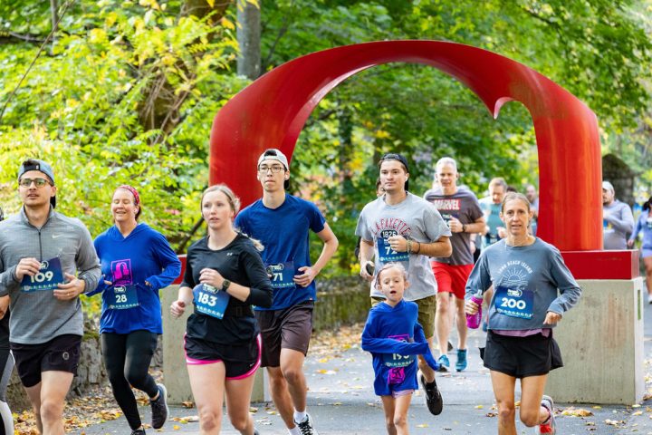 A group of runners go through the iconic red arch sculpture during the Artful Dash 5K Run/Walk on the Karl Stirner Arts Trail in Easton, Pennsylvania.