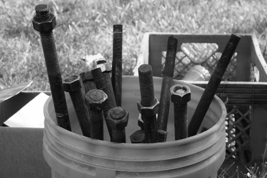 A bucket holds large metal screws used to install the recycled rubber tire sculpture by Chakaia Booker, No More Milk and Cookies, on the Karl Stirner Arts Trail in Easton, Pennsylvania.