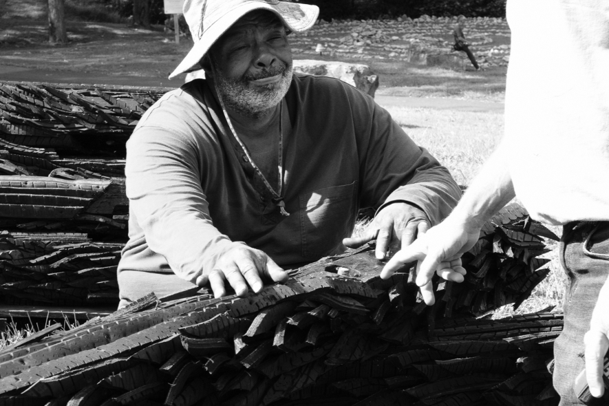 A man with a hat smiles as he helps with the installation of the recycled rubber tire sculpture by Chakaia Booker, No More Milk and Cookies, on the Karl Stirner Arts Trail in Easton, Pennsylvania.